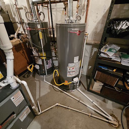 A water heater in a basement next to a heater