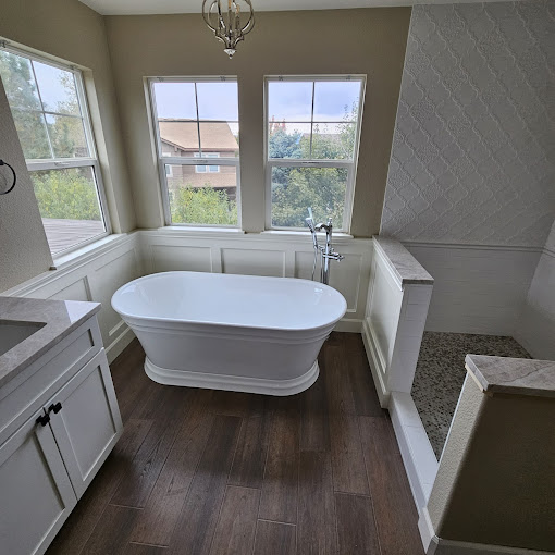 A bathroom with a tub, sink, and window